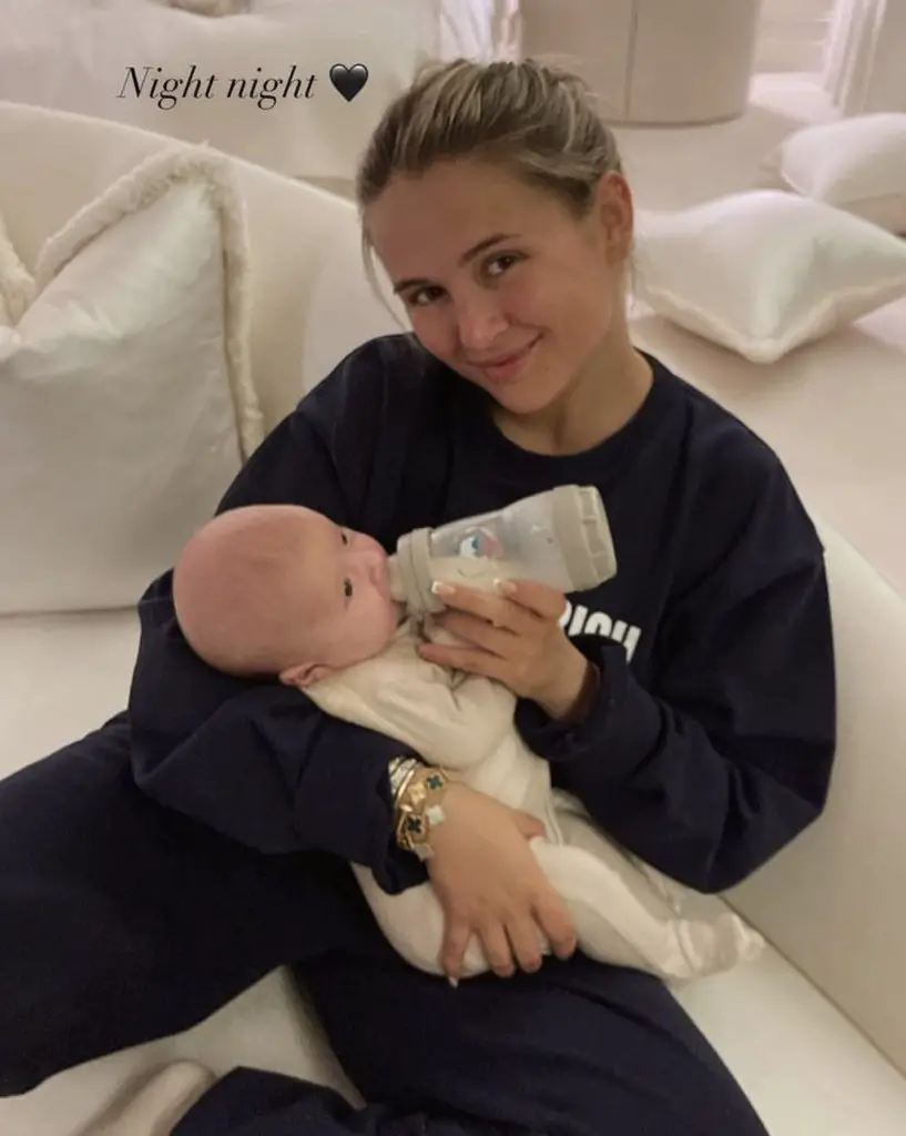 Molly-Mae Hague holding a baby bottle in her hands while feeding her baby